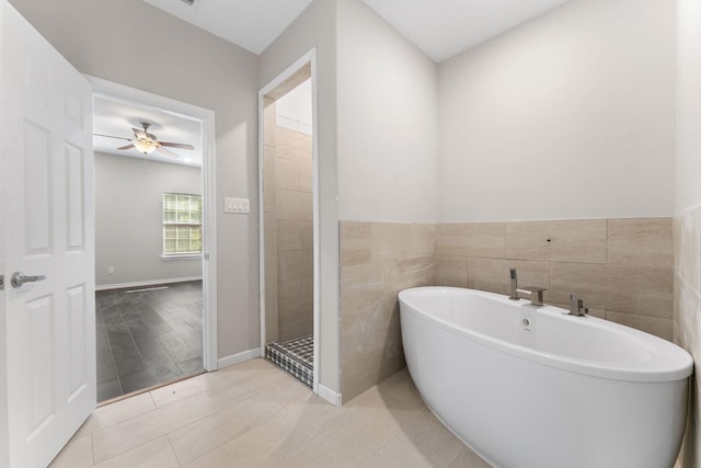 3504 Keyridge Dr, Dallas, TX 75241 - bathroom with a soaking tub, a ceiling fan, tile walls, tile patterned floors, and tiled shower