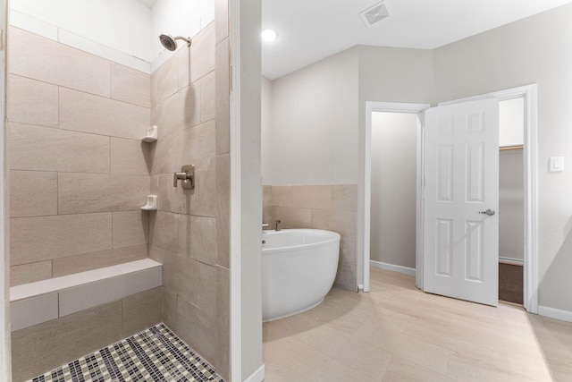 3504 Keyridge Dr, Dallas, TX 75241 - full bath featuring a tile shower, a freestanding bath, a walk in closet, and tile patterned flooring