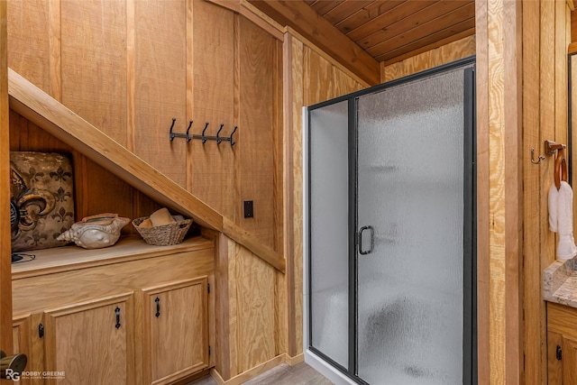 full bath featuring wooden walls, wood ceiling, and a stall shower