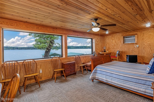 carpeted bedroom with wood ceiling, wood walls, a wall mounted air conditioner, and a water view