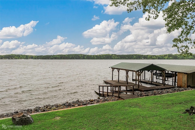 view of dock with boat lift, a yard, and a water view