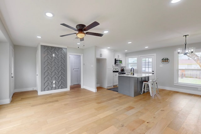 10503 Cayuga Dr, Dallas, TX 75228 - kitchen featuring appliances with stainless steel finishes, baseboards, a breakfast bar, recessed lighting, and white cabinetry
