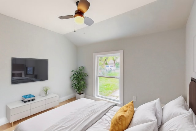 bedroom featuring vaulted ceiling, light wood finished floors, and a ceiling fan