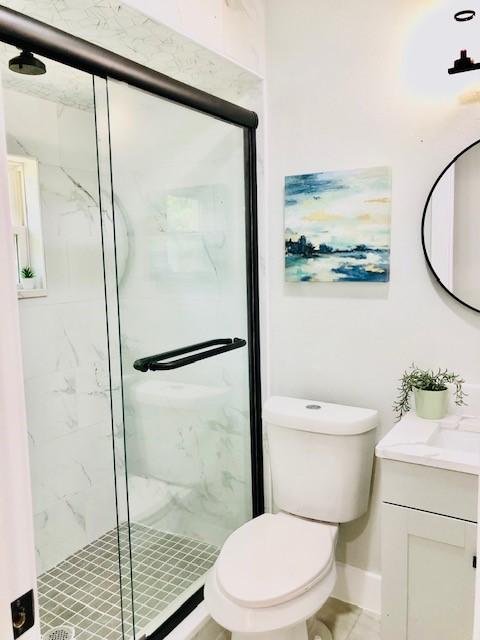 10503 Cayuga Dr, Dallas, TX 75228 - bathroom featuring a marble finish shower, vanity, and toilet