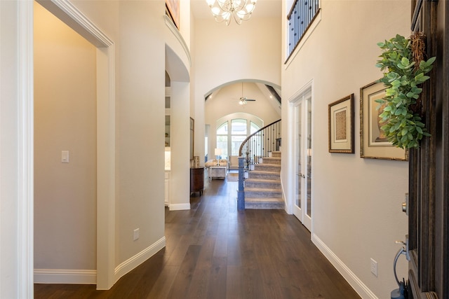 2813 Maverick Way, Celina, TX 75009 - entryway featuring arched walkways, a chandelier, dark wood-style floors, baseboards, and stairway