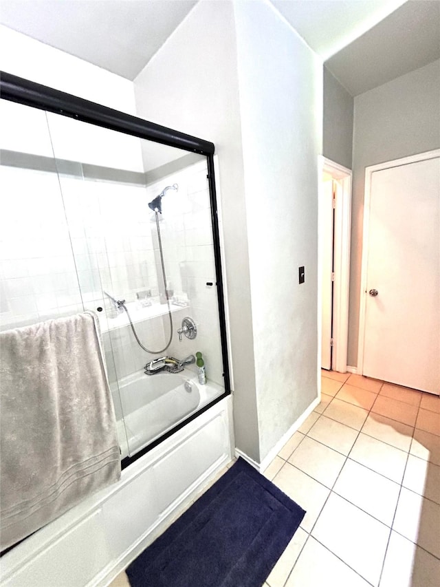 bathroom with combined bath / shower with glass door, baseboards, and tile patterned flooring