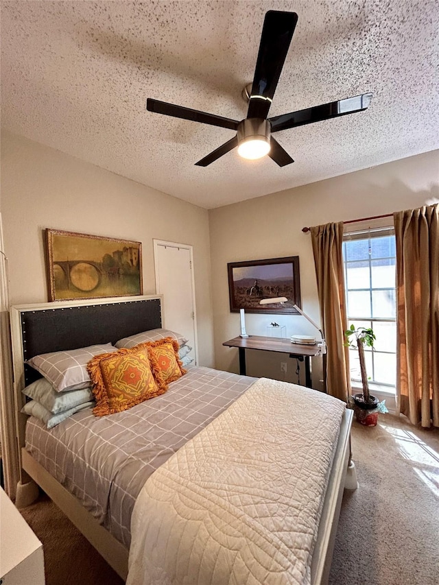 bedroom with carpet floors, a textured ceiling, and a ceiling fan