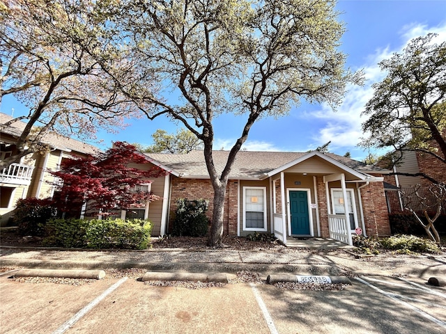 view of front of house featuring brick siding and uncovered parking