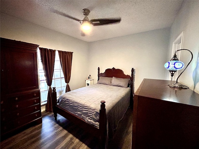 bedroom with a textured ceiling, ceiling fan, and dark wood finished floors