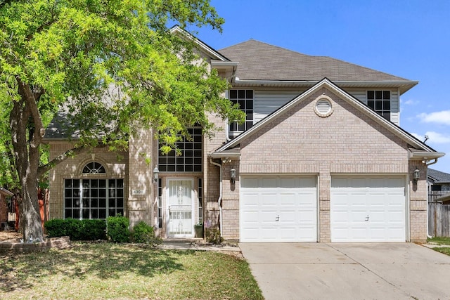 traditional-style house featuring brick siding, a garage, and driveway