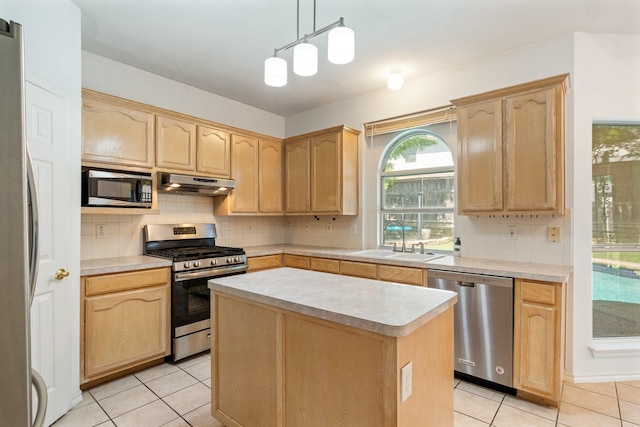 kitchen featuring a sink, light countertops, appliances with stainless steel finishes, light brown cabinetry, and under cabinet range hood