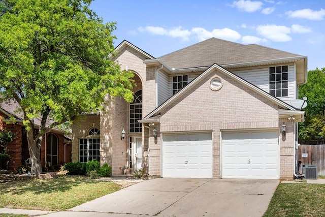 traditional home featuring concrete driveway, an attached garage, brick siding, central AC unit, and a shingled roof