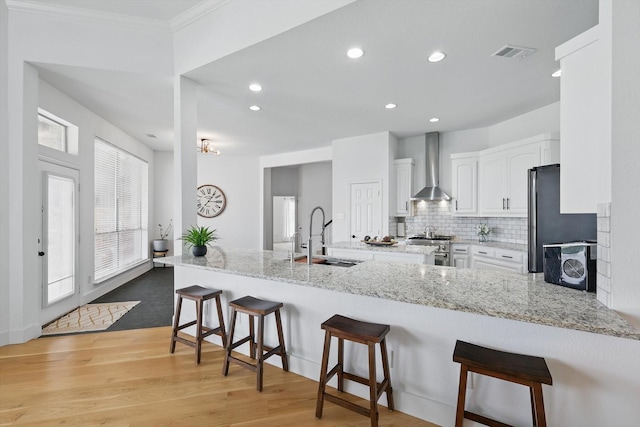 809 Chiswick Ct, Haslet, TX 76052 - kitchen with a sink, wall chimney exhaust hood, white cabinetry, stainless steel appliances, and recessed lighting