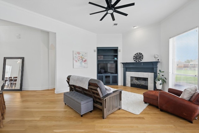 809 Chiswick Ct, Haslet, TX 76052 - living room featuring a ceiling fan, ornamental molding, a fireplace, light wood finished floors, and built in shelves