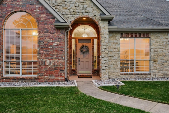 809 Chiswick Ct, Haslet, TX 76052 - property entrance with roof with shingles, stone siding, brick siding, and a yard