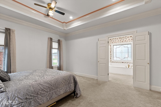 carpeted bedroom with crown molding, baseboards, connected bathroom, ceiling fan, and a raised ceiling