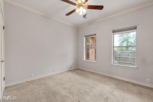 carpeted empty room with crown molding, baseboards, and ceiling fan