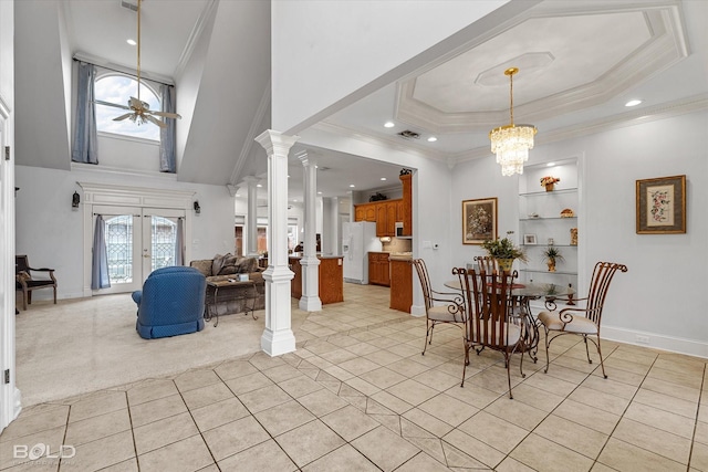 dining room with a raised ceiling, light tile patterned floors, crown molding, and baseboards