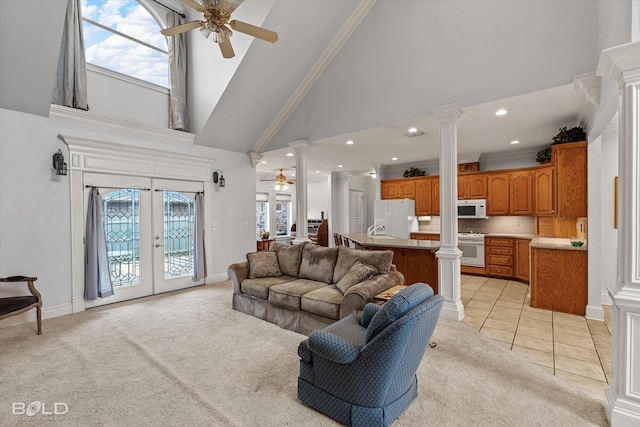 living area with decorative columns, french doors, light tile patterned floors, light colored carpet, and ceiling fan