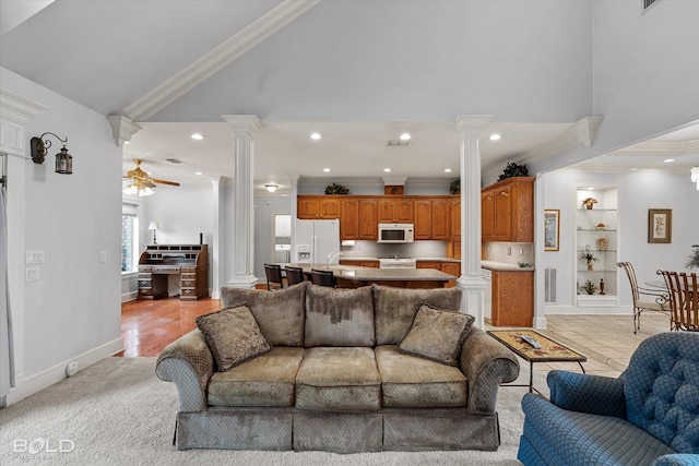 living area featuring ornate columns, ornamental molding, high vaulted ceiling, and a ceiling fan