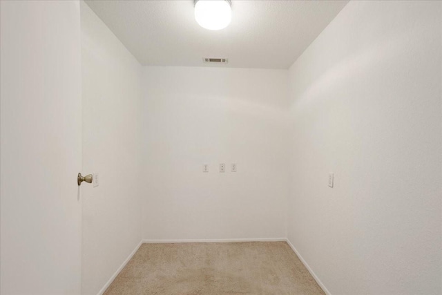 interior space with visible vents, light colored carpet, and baseboards