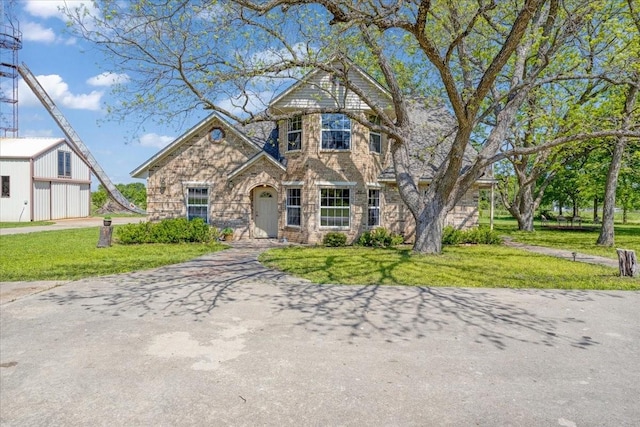 view of front of property with a front lawn, stone siding, and a garage
