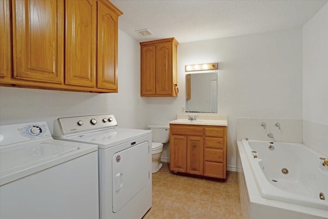 washroom featuring laundry area, light tile patterned floors, washer and dryer, a sink, and visible vents