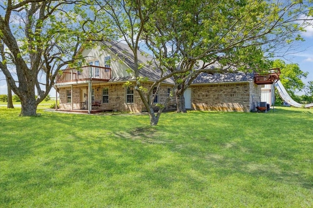 rear view of house with a wooden deck, a yard, central air condition unit, and brick siding