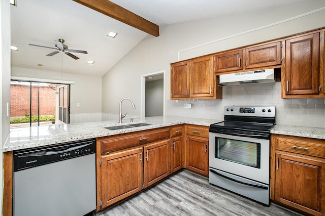 kitchen with under cabinet range hood, a sink, light wood-style floors, a peninsula, and appliances with stainless steel finishes