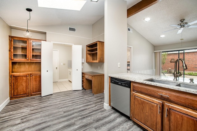 kitchen featuring brown cabinetry, dishwasher, a sink, and light wood-style flooring