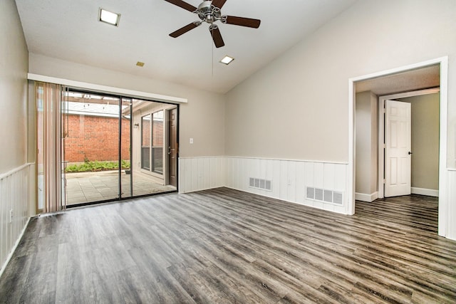 spare room featuring vaulted ceiling, a ceiling fan, wood finished floors, and visible vents