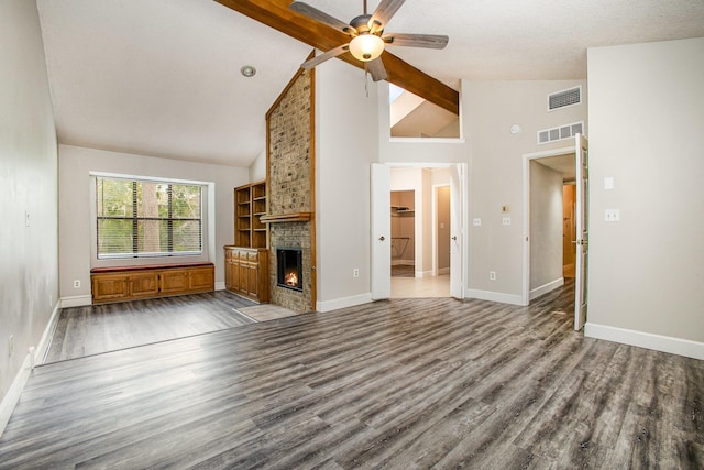 unfurnished living room featuring a brick fireplace, wood finished floors, visible vents, and ceiling fan