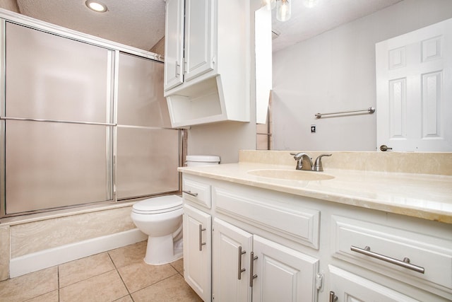 bathroom featuring tile patterned floors, a textured ceiling, shower / bath combination with glass door, toilet, and vanity