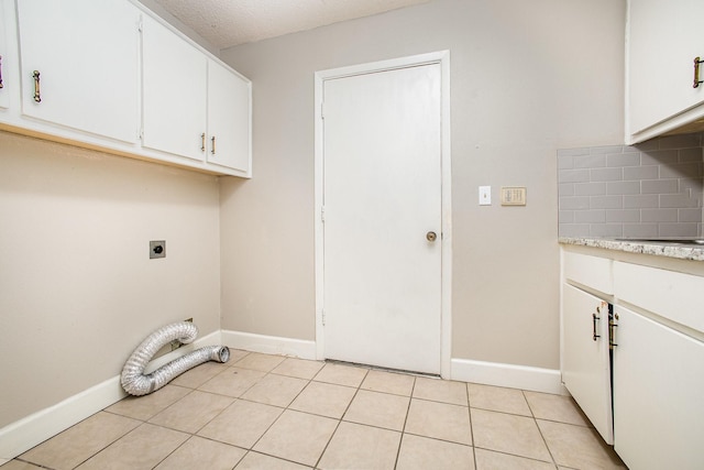 laundry area featuring electric dryer hookup, baseboards, and cabinet space
