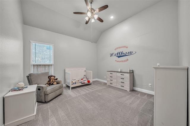 carpeted bedroom with vaulted ceiling, a ceiling fan, a crib, and baseboards