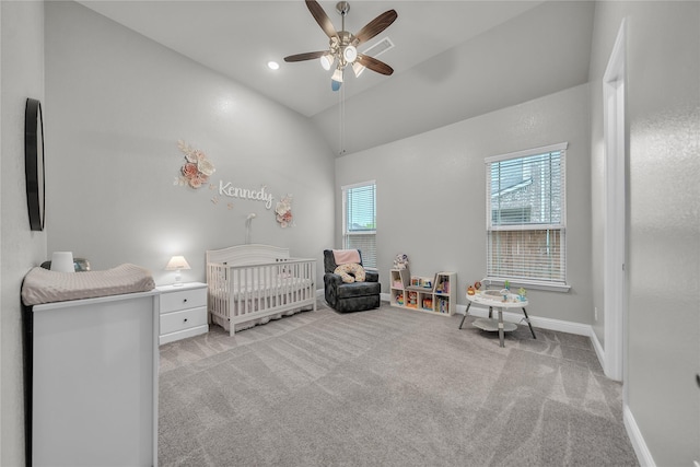 carpeted bedroom with high vaulted ceiling, a nursery area, baseboards, and a ceiling fan