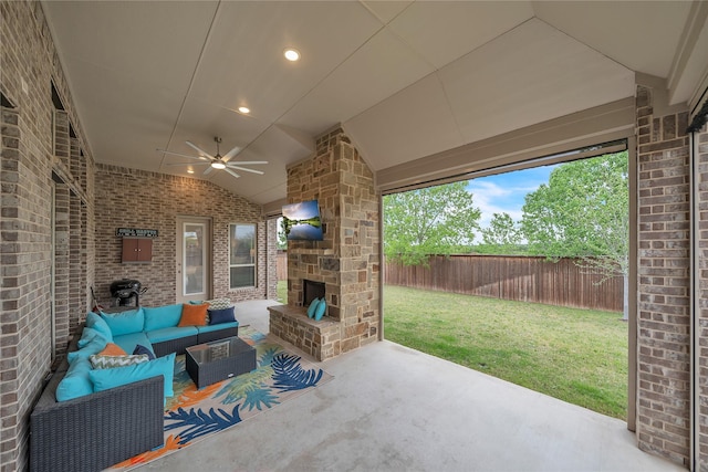 view of patio / terrace with an outdoor living space with a fireplace, a fenced backyard, and ceiling fan