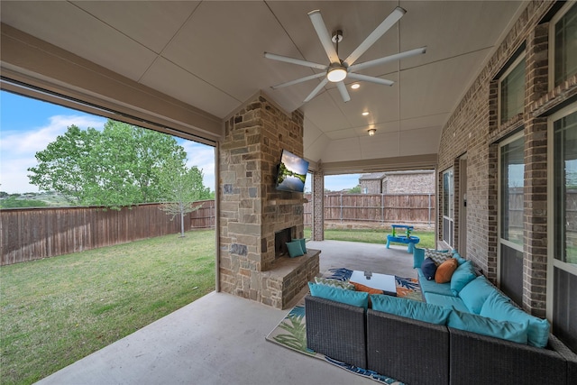 view of patio / terrace with an outdoor living space with a fireplace, a ceiling fan, and a fenced backyard