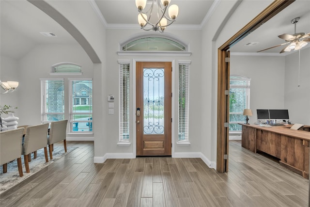 entrance foyer with arched walkways, light wood-style floors, baseboards, and ceiling fan with notable chandelier