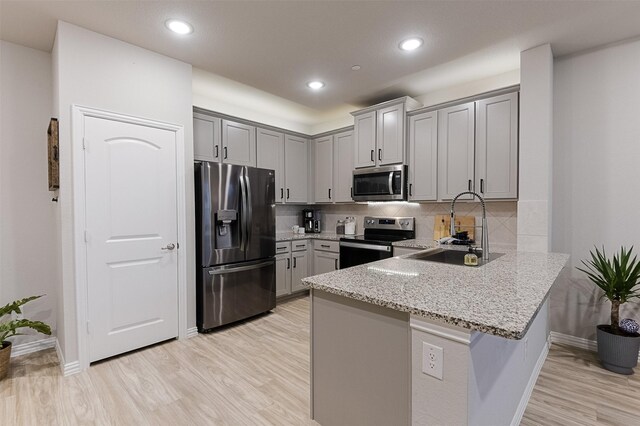 2728 Baneberry Ln, Mesquite, TX 75150 - kitchen with stainless steel appliances, a sink, a peninsula, light stone counters, and gray cabinets