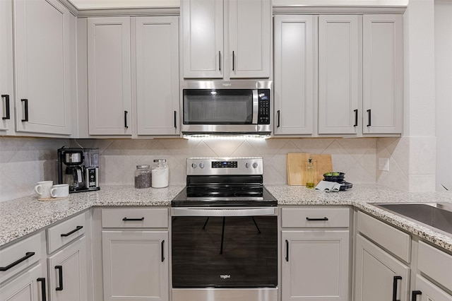 2728 Baneberry Ln, Mesquite, TX 75150 - kitchen with stainless steel appliances, a sink, decorative backsplash, and light stone countertops