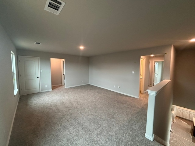 carpeted empty room featuring visible vents and baseboards