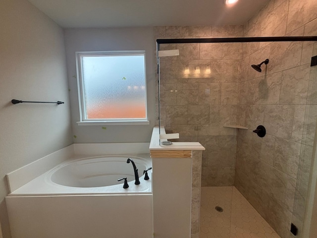 bathroom featuring a garden tub and a tile shower