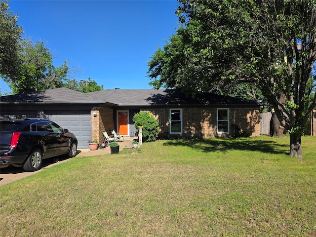 ranch-style home featuring concrete driveway, an attached garage, brick siding, and a front yard