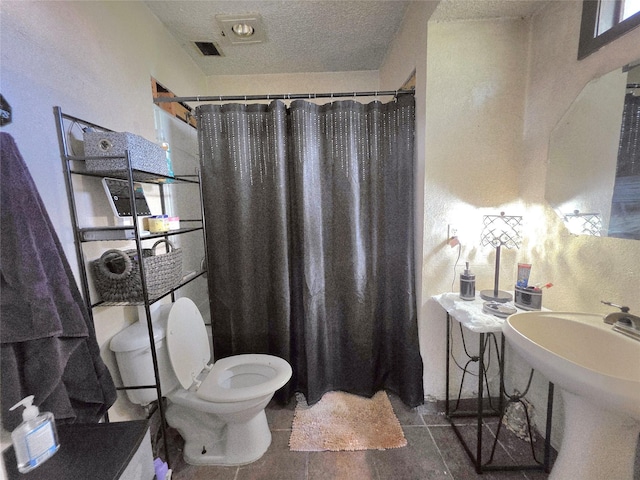 full bathroom featuring toilet, a textured ceiling, visible vents, tile patterned floors, and a shower with shower curtain