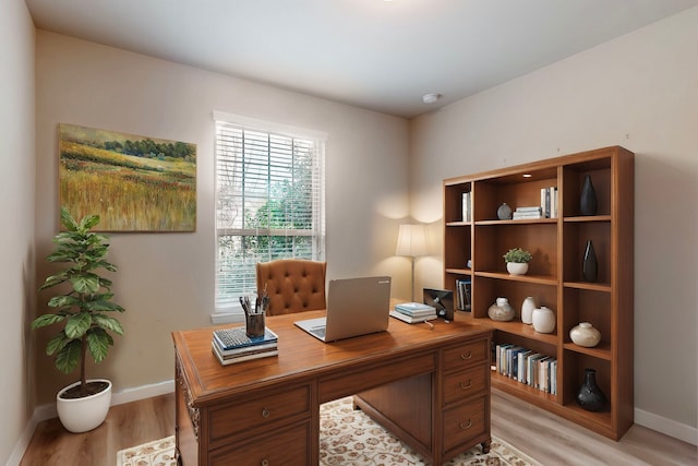home office featuring light wood finished floors, baseboards, and plenty of natural light