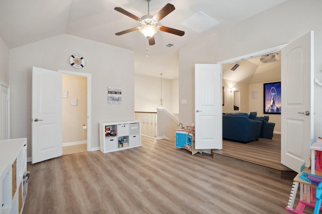 rec room featuring baseboards, vaulted ceiling, light wood-style floors, visible vents, and ceiling fan