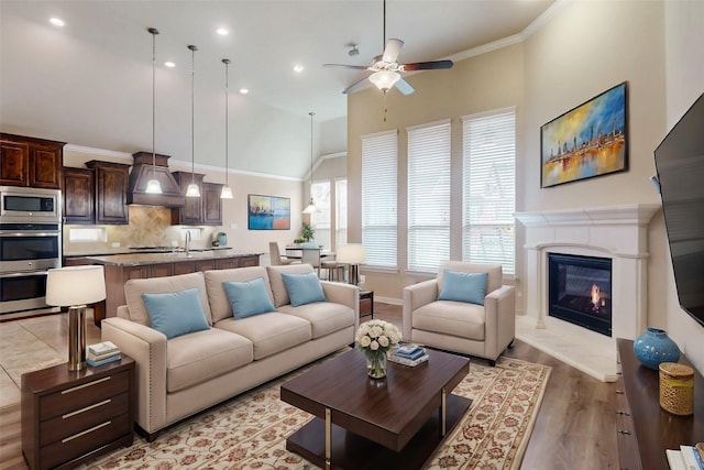 living room featuring high vaulted ceiling, ceiling fan, recessed lighting, a high end fireplace, and baseboards