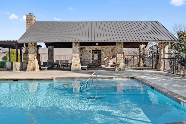 community pool with a patio area and fence