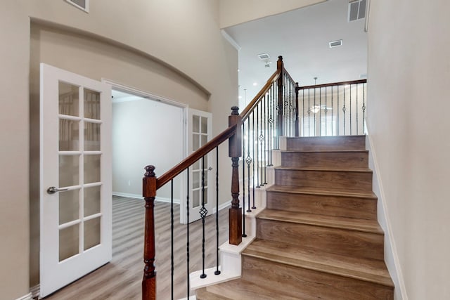 stairs with visible vents, french doors, baseboards, and wood finished floors